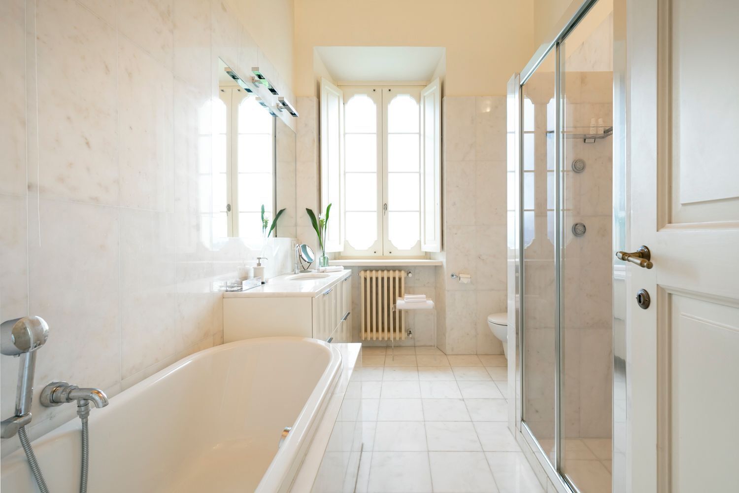 A modern bathroom with a bathtub, shower, and glass-enclosed shower area.