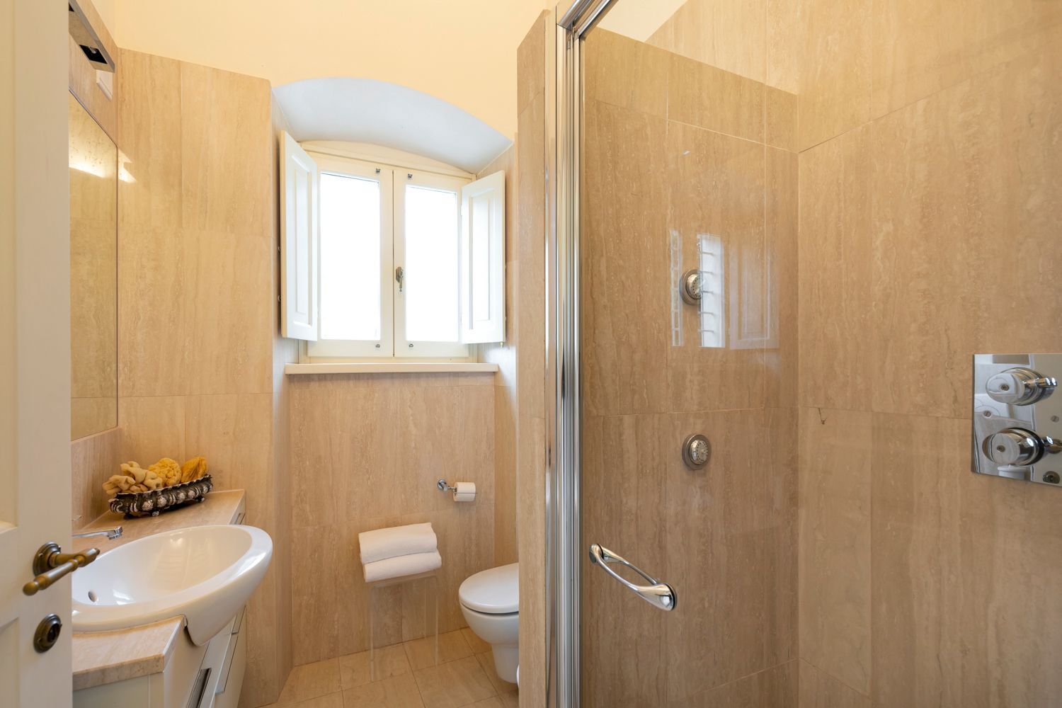 Et badeværelse med vask, toilet og bruser.