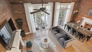 A spacious living area with a fireplace, a dining table, and a sofa.