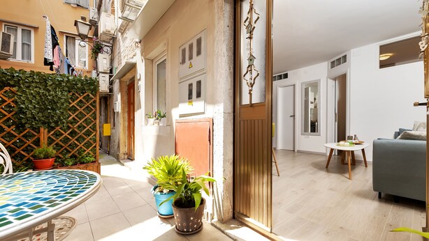 A modern living room with a sofa, a small round table, and a potted plant. - Apartment Amici (Rovinj)