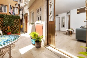 A modern living room with a sofa, a small round table, and a potted plant. - Apartment Amici (Rovinj)