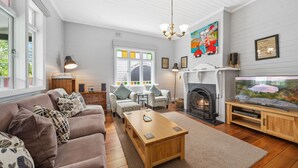 Ein gemütliches Wohnzimmer mit Kamin, einer Couch, einem Couchtisch und einem Fernseher.
