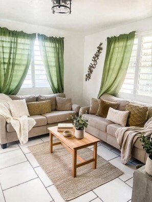 Ein Wohnzimmer mit zwei Sofas, einem Couchtisch und einer Topfpflanze.