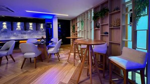 A modern bar area with wooden furniture and a blue-lit wall. - Flat Premium Ozean Home & Service - João Pessoa (João Pessoa)