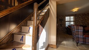 Un escalier en bois dont les marches sont marquées de lettres, menant à un mur de pierre et à une fenêtre.