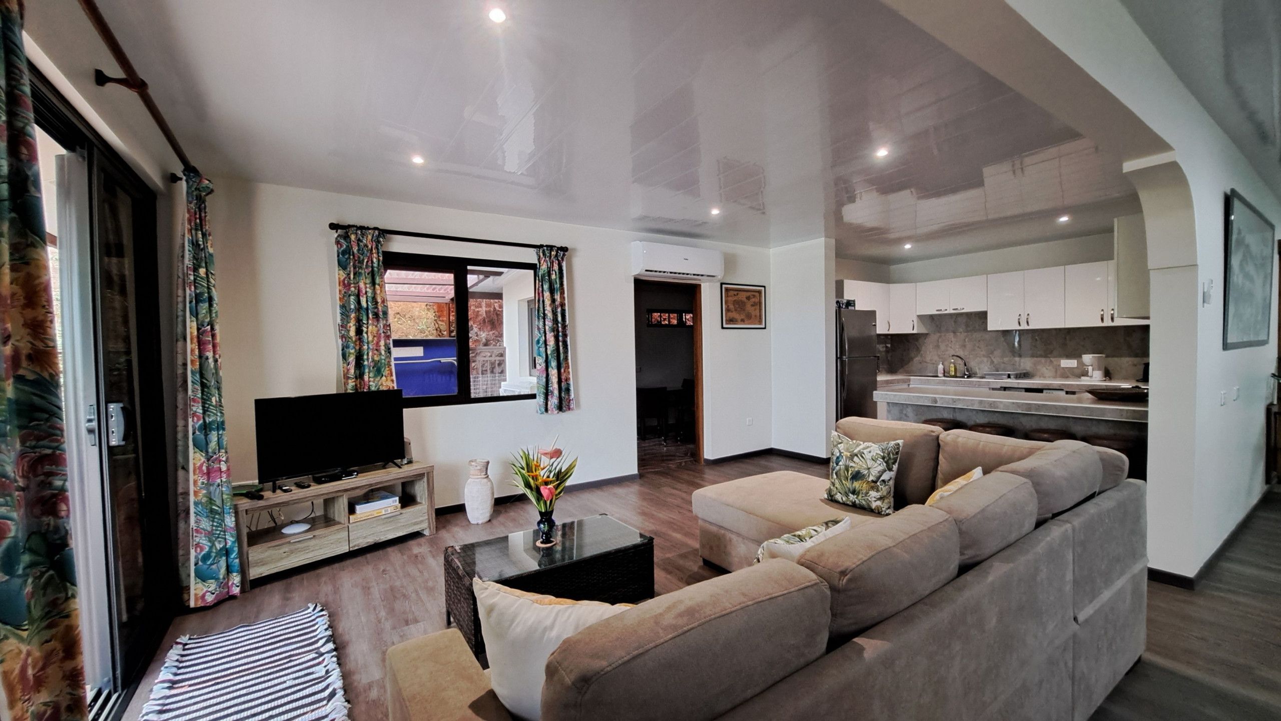 A modern living room with a flat-screen TV, sofa, and coffee table.
