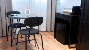 A compact kitchenette with a small refrigerator, a coffee machine, and a table with chairs. - ROMA MIA IN TRASTEVERE (Rome)