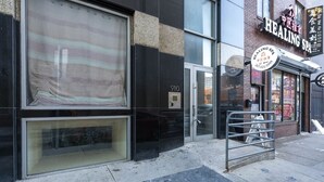 Fachada de edificio con un amplio ventanal y una puerta de metal.