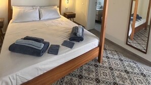 Ein Himmelbett mit aufgerollten Handtüchern und einem Spiegel an der Wand.