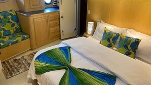 A hotel room with a bed, a sofa, a nightstand, and a wardrobe.