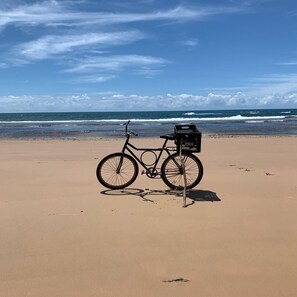 Di pantai, kursi berjemur, payung pantai, dan handuk pantai
