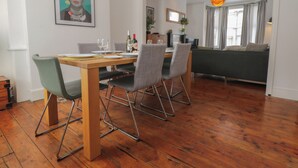 A dining area with a wooden table, four chairs, and a painting on the wall. - 6 Sydney Road (Ramsgate)