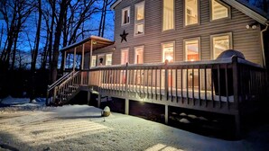 A two-story house with a deck and a star decoration on the wall.