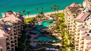 A resort with multiple buildings, a central pool area, and a view of the ocean. - Beachfront, Premium Ocean View, 5 Star (Cabo San Lucas)