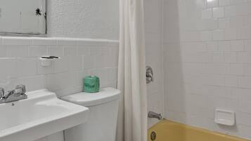 A bathroom with a white toilet, a sink, and a bathtub.