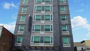 A multi-story building with a modern architectural design, featuring a symmetrical facade with evenly spaced windows and a central entrance.