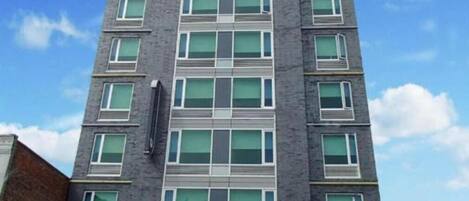 A multi-story building with a modern architectural design, featuring a symmetrical facade with evenly spaced windows and a central entrance.