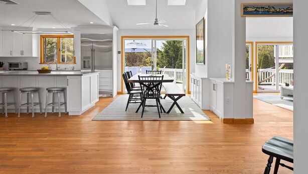A spacious kitchen with a dining area, large windows, and a view of the outdoors. - Beach Getaway - Spacious Katama Beach House (Edgartown)