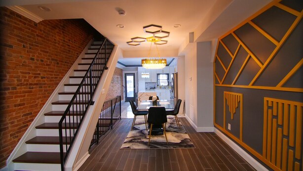 A modern interior with a staircase, a dining area, and a kitchen. - Lux Stay near Patterson Park, John Hopkins, & Stadiums! Family & Pet-Friendly. (Baltimore)
