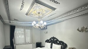 A bedroom with a large bed, a desk, a chair, and a chandelier. - X SAPANCA OTEL (Sapanca)