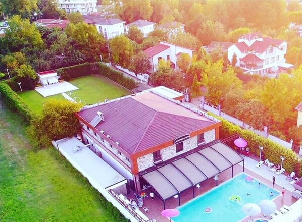 A large building with a swimming pool and outdoor seating area.