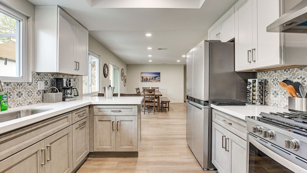 A modern kitchen with light wood cabinets, stainless steel appliances, and a central island. - Spacious Oceanside Family Home w/ Fenced-In Yard (Oceanside)