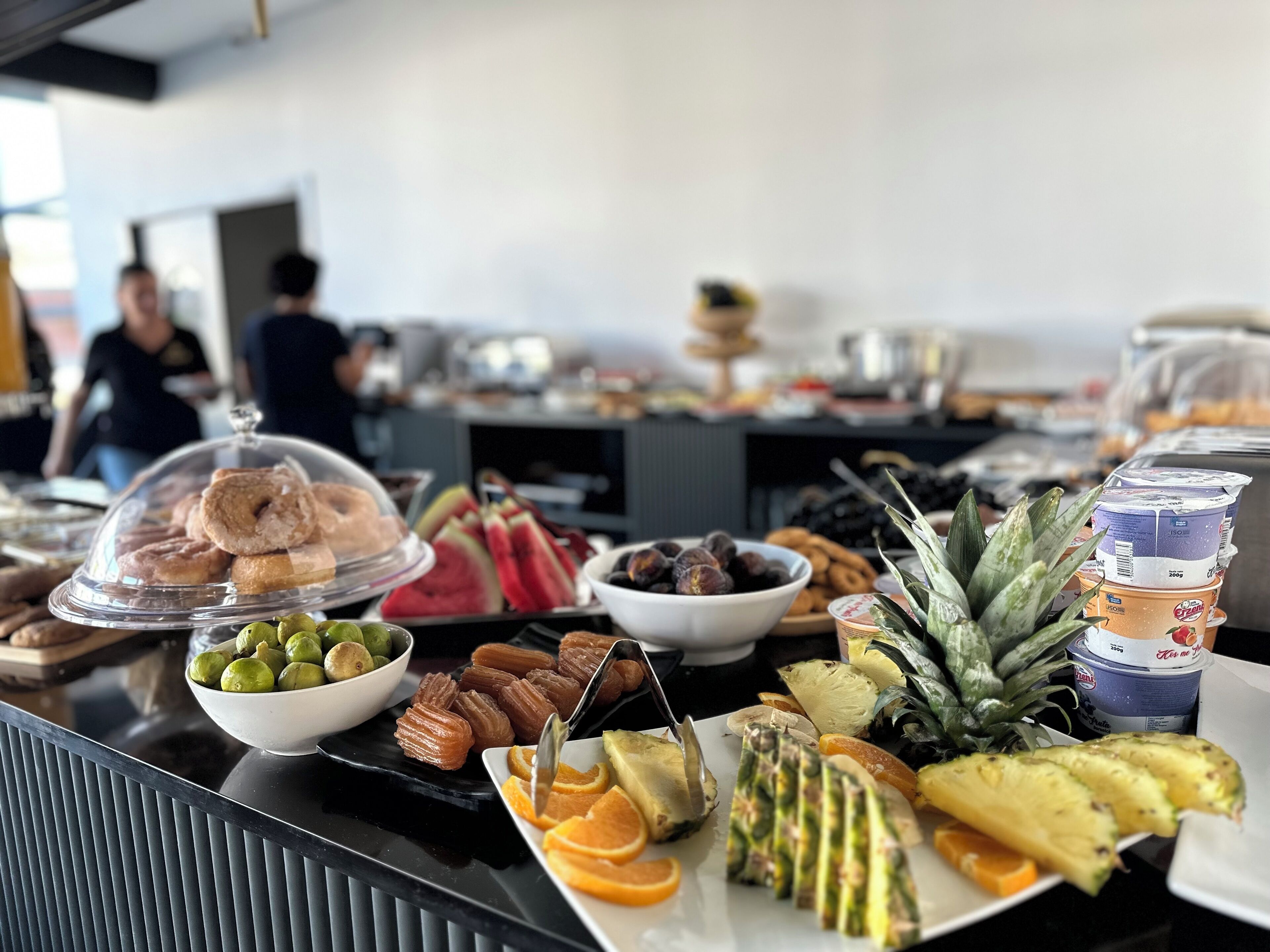 A buffet with various food items including pastries, fruits, and desserts.