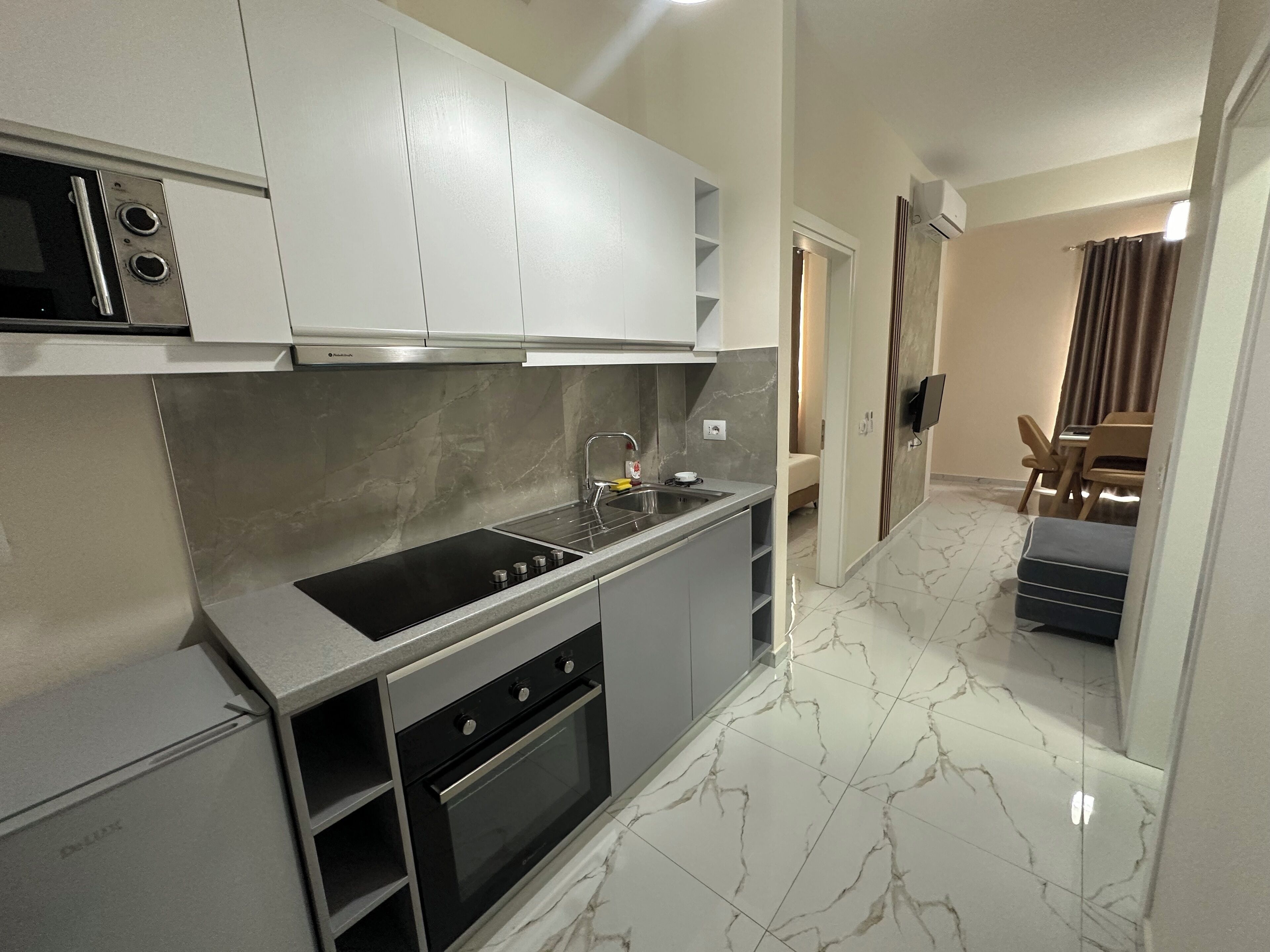 A modern kitchen with a built-in oven, a stovetop, and a sink.