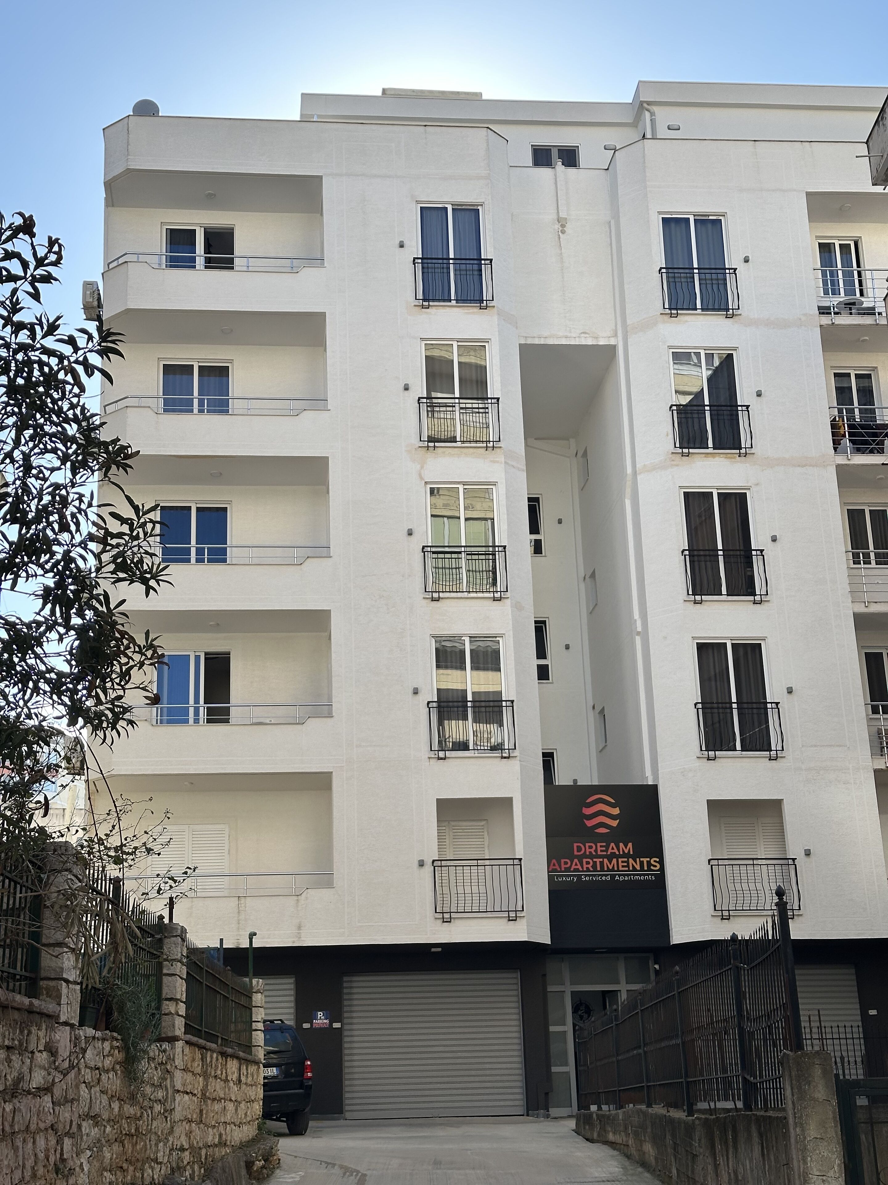 A multi-story building with balconies, a garage door, and a sign for Dream Apartments.