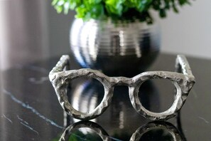 A pair of glasses with a textured frame on a reflective surface.