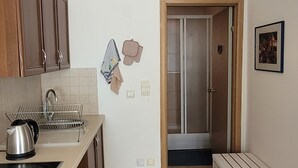 Une cuisine avec des meubles de rangement en bois, une cuisinière, un évier et un banc.