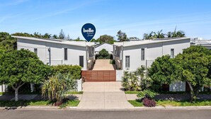 A property with a central entrance, symmetrical design, and a sign indicating it's a boutique hotel. - Villa Marguerite - walking distance to the beach (Coolum Beach)