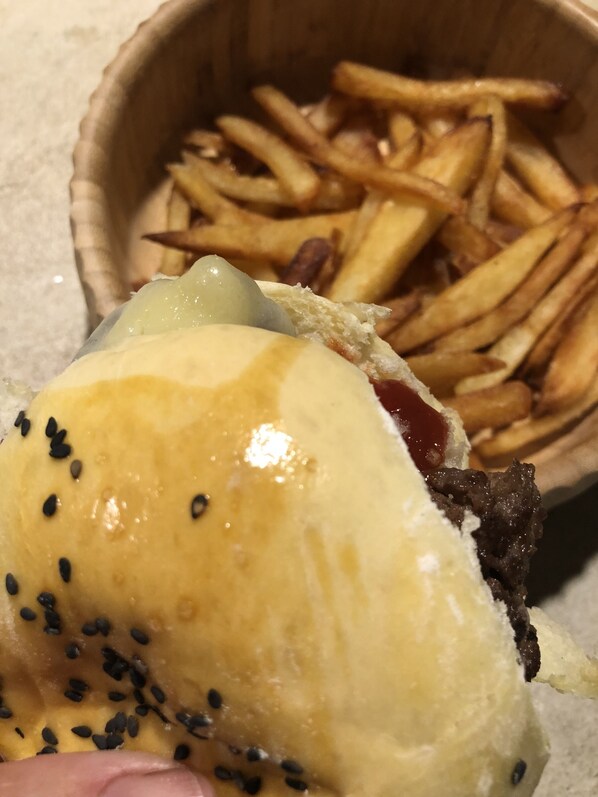 A sandwich with sesame seeds and a side of French fries. - VILLA CÉU (Maraú)
