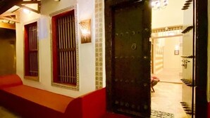 A building with a tiled entrance, a large metal door, and a small window with bars. - The Island Stone Town Hotel  (Zanzibar Town)