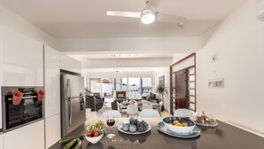 A modern kitchen with a central island, stainless steel appliances, and a view to the dining area. - Faros Beachfront Villa Larnaca (Larnaca)