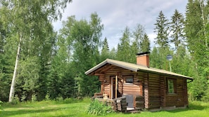 A small log cabin with a chimney, a door, and a window. - Koivula Fish Cottage (Sulkava)