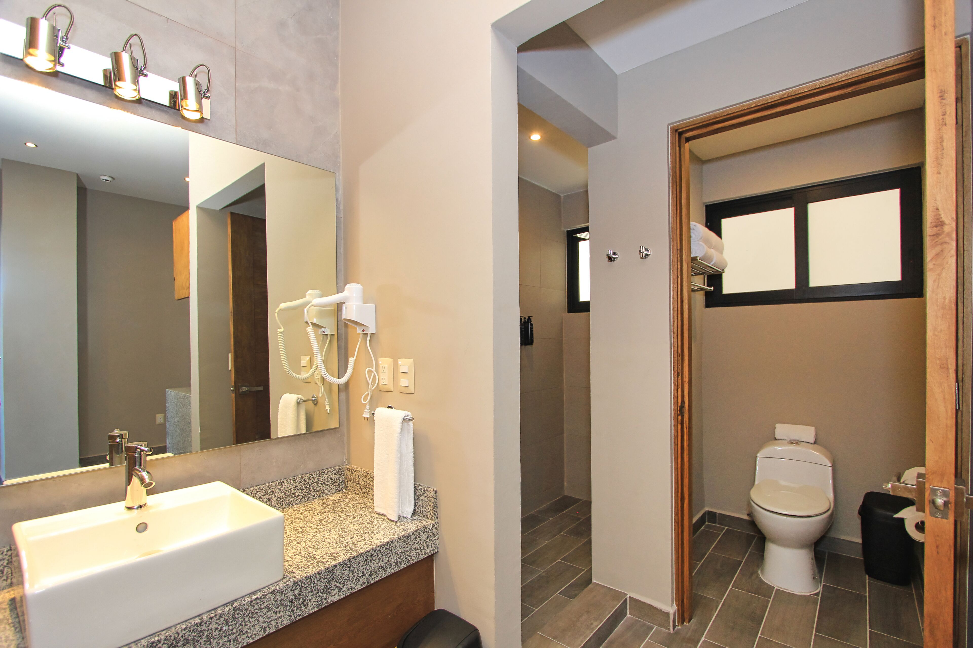 Une salle de bain équipée d’un lavabo, d’un miroir, d’un porte-serviettes et de toilettes.