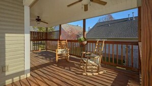 Eine Holzterrasse mit zwei Schaukelstühlen und einem Deckenventilator.