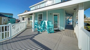 A coastal house with a covered porch, outdoor seating, and a view of the ocean. - Holiday Beach House by Avantstay Pool + Beach (Port Aransas)