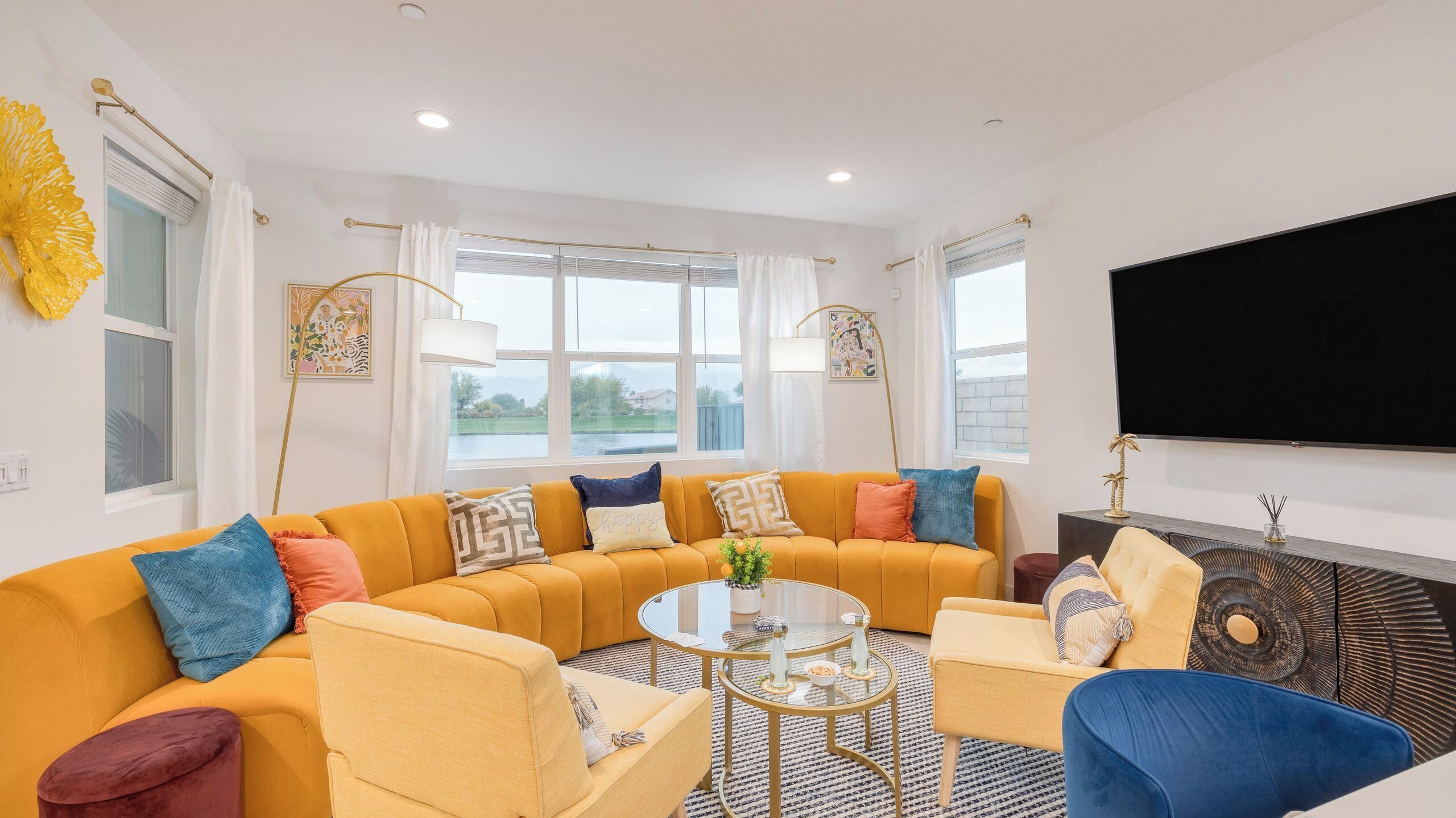 A living room with a sectional sofa, a coffee table, a TV, and a fireplace.