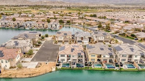 Zona residencial con casas, una piscina y un campo de golf al fondo.