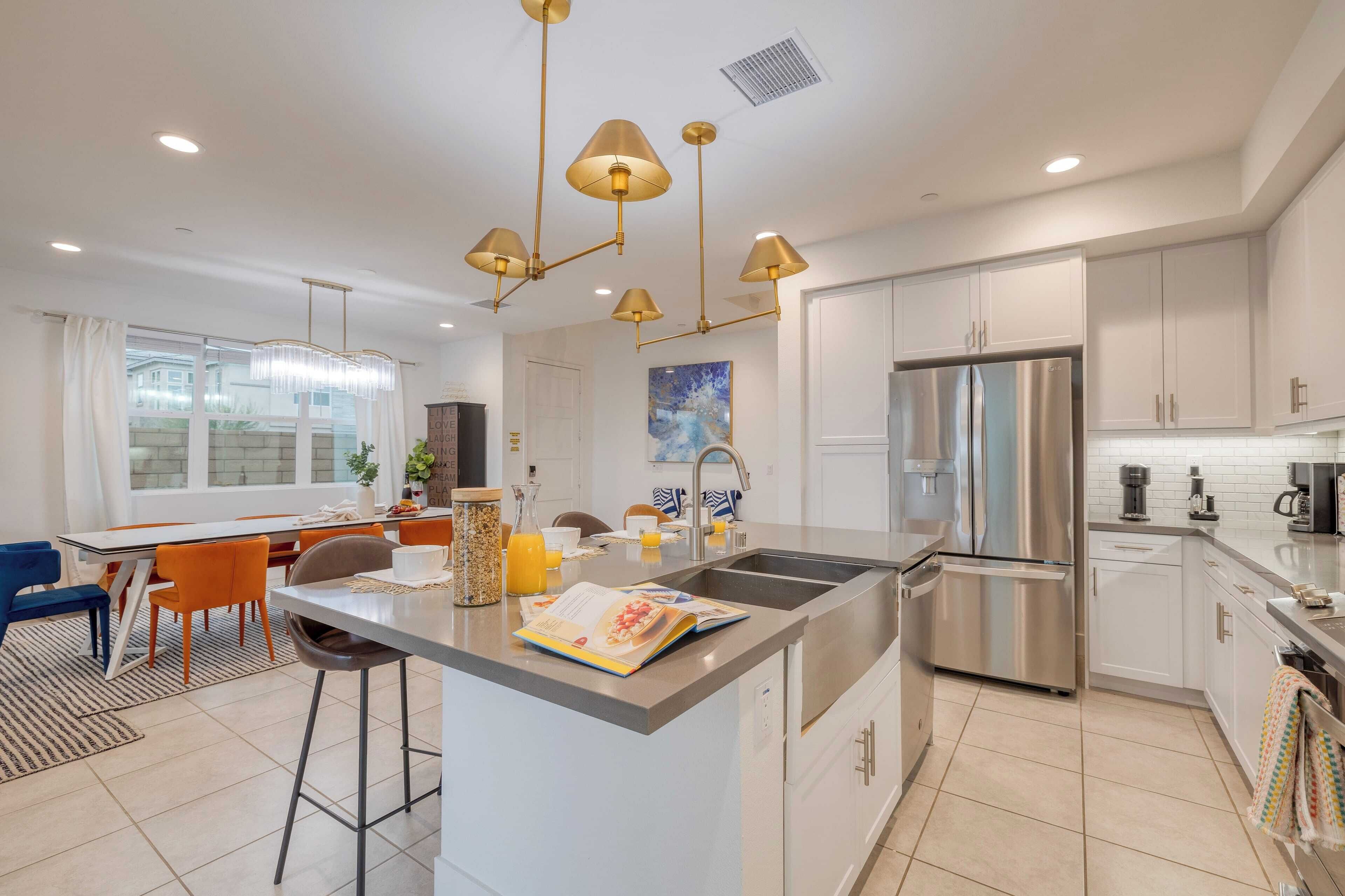 A modern kitchen with a central island, stainless steel appliances, and pendant lighting.