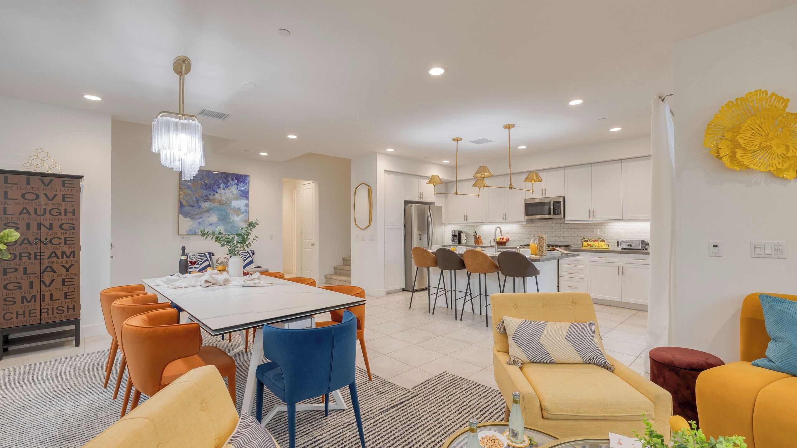 A modern kitchen with white cabinets, a stainless steel refrigerator, and a microwave.