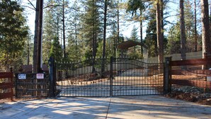 Un cancello d'ingresso conduce a una proprietà circondata da alberi alti.
