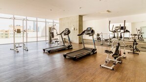 Ein geräumiger Fitnessraum mit Laufbändern, Crosstrainern und Gewichtsmaschinen.