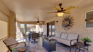 A patio with a ceiling fan, a sofa, a table, and chairs. - Furnished Patio, Grill & Views: Lake Havasu Home (Lake Havasu City)