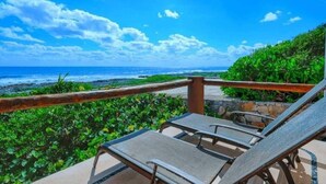A balcony with two lounge chairs overlooking a beach with waves and a clear sky. - Extraordinary Ocean Views - 2 bed / 2 bath and pool (Akumal)