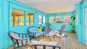 A turquoise-colored porch with wooden flooring, a glass-top table, and several chairs and a sofa. - Lanikai- POOL/GAME RM/BAY & BCH ACCESS! (Virginia Beach)