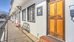 Un bâtiment avec une rangée de fenêtres, une porte en bois et un banc sur le trottoir.