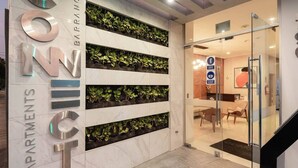 A modern lobby with a vertical garden, a reception desk, and a staircase. - Ocean View 1BR - TV 65" - Pool - Jacuzzi 1606 (Barranco)